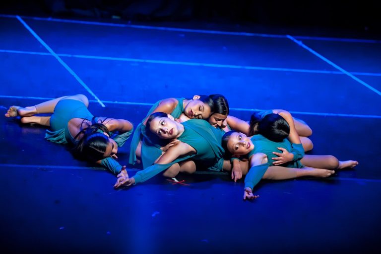 A group of young children are laying on the floor.