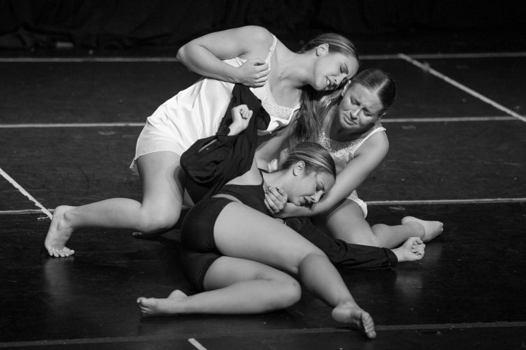 Three women are on the ground and one is holding a knife.